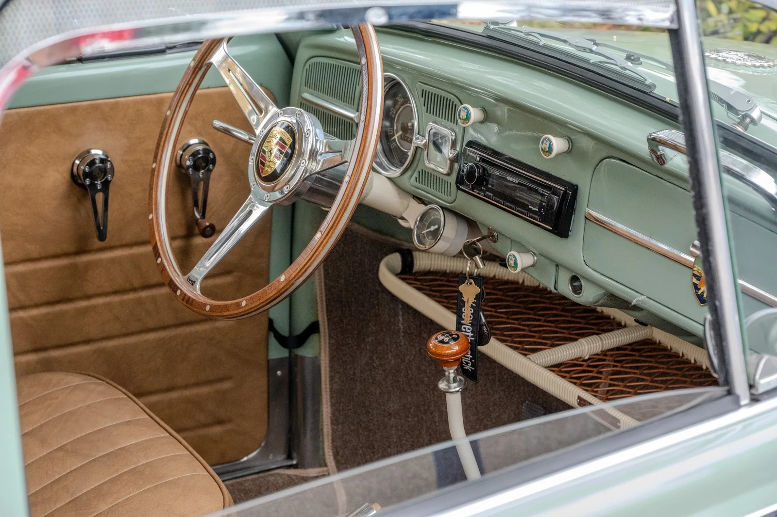 Volkswagen Beetle dashboard and wood-rimmed steering wheel bearing a Porsche crest.