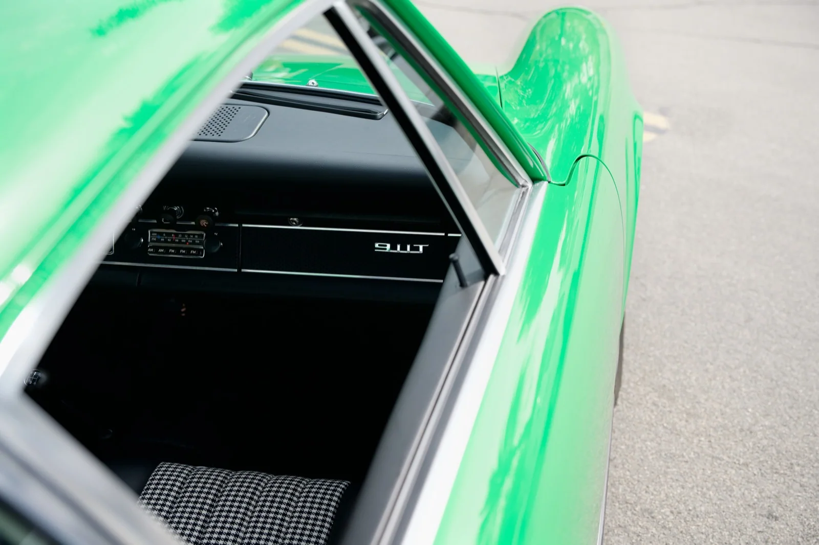 Green Porsche window frame, dashboard, and patterned seat.