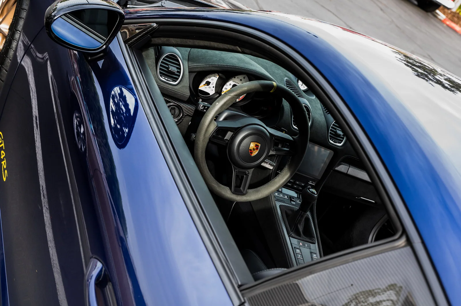 Porsche Cayman cockpit viewed through its blue window frame.
